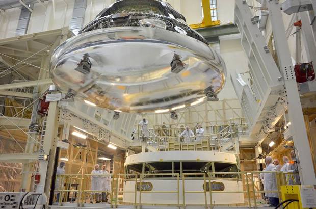 Orion, seen here with its heat shield installed, being maneuvered for stacking on the spacecraft’s service module at KSC earlier this month. (Credit: NASA)
