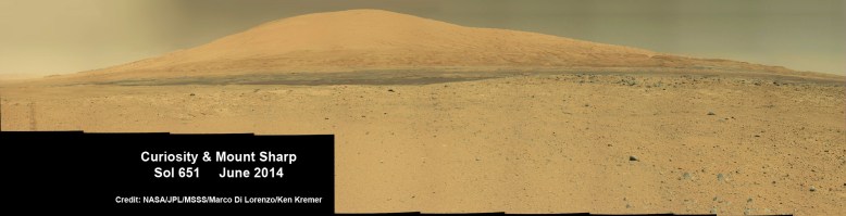 Curiosity rover panorama of Mount Sharp captured on June 6, 2014 (Sol 651) during traverse inside Gale Crater. Note rover wheel tracks at left. She will eventually ascend the mountain at the ‘Murray Buttes’ at right later this year. Assembled from Mastcam color camera raw images and stitched by Marco Di Lorenzo and Ken Kremer. Credit: NASA/JPL/MSSS/Marco Di Lorenzo