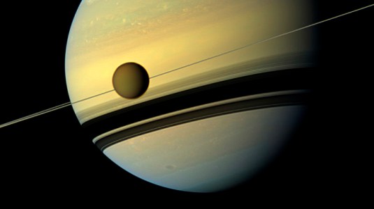 Titan, Saturn's largest moon appears before the planet as it undergoes seasonal changes in this natural color view from NASA's Cassini spacecraft in this handout released by NASA August 29, 2012. (Reuters/NASA)