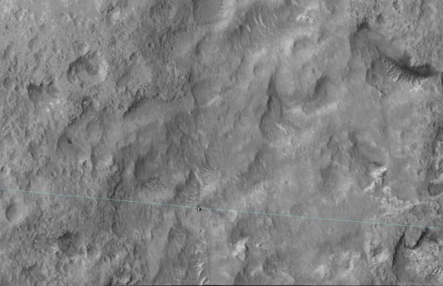 The blue line added to this June 27, 2014, image from the High Resolution Imaging Science Experiment (HiRISE) camera on NASA's Mars Reconnaissance Orbiter is the edge of the ellipse that was charted as safe terrain for the rover's August 2012 landing. Curiosity is visible right on the ellipse line in the lower center of the image. This 3-sigma landing ellipse is about 4 miles long and 12 miles wide (7 kilometers by 20 kilometers). Curiosity reached the edge of it for the first time with a drive of about 269 feet (82 meters) earlier that day. (Credit: NASA)