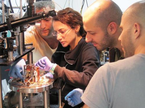  This image depicts from left to right Serge Rosenblum, Yulia Lovsky, Orel Bechler and Itay Shomroni.  At the center of the photonic router is a single atom that routes photons  in different directions. (Credit: Weizmann Institute of Science)