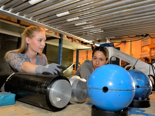 Los Alamos National Laboratory postdoc Elena Guardincerri, right, and undergraduate research assistant Shelby Fellows prepare a lead hemisphere inside a muon tomography machine. (Credit: Los Alamos National Laboratory)