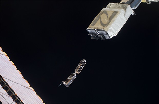 In the grasp of the Japanese robotic arm, NanoRack’s CubeSat deployer releases a pair of miniature satellites last month. (Credit: NASA)