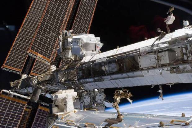 The starboard truss of the International Space Station while Space Shuttle Endeavour docked with the station. The newly installed Alpha Magnetic Spectrometer (AMS) is visible at center left. (Credit: NASA)
