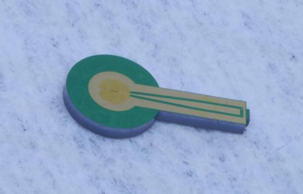 NIST chip containing a single-photon detector was made of superconducting nanowires. Four chips like this were used in the experiment that entangled three photons.  (Credit: Verma/NIST)
