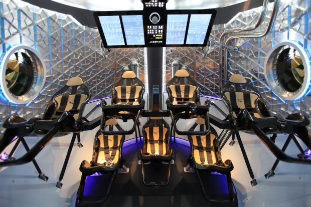  The Wait For Space A look through the open hatch of SpaceX's Dragon V2 capsule, one of two designs chosen for NASA's Commercial Crew Transportation Capability program. Both Boeing and SpaceX have been told to halt production of their space taxi designs until a protest filed by the Sierra Nevada Corporation has been resolved. (Credit: NASA)