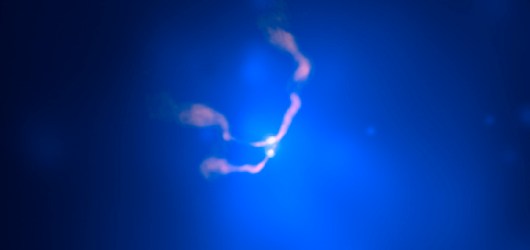 his composite X-ray/radio image of Abell 400 shows radio jets (pink), immersed in a vast cloud of multimillion degree X-ray emitting gas (blue) that pervades the cluster. The jets emanate from the vicinity of two supermassive black holes (bright spots in the image) in the galaxy. Chandra and radio data confirm that the unusual structure is due to the merger of two large galaxies, whose supermassive black holes are bound together by their mutual gravity. The swept-back appearance of the radio jets is produced by the rapid motion of the galaxy through the hot gas of the cluster, in much the same way that a motorcyclist's scarf is swept back while speeding down the road.Credit: X-Ray: NASA/CXC/D. Hudson, T.Reiprich et al. (AIfA); Radio: NRAO/VLA/ NRL